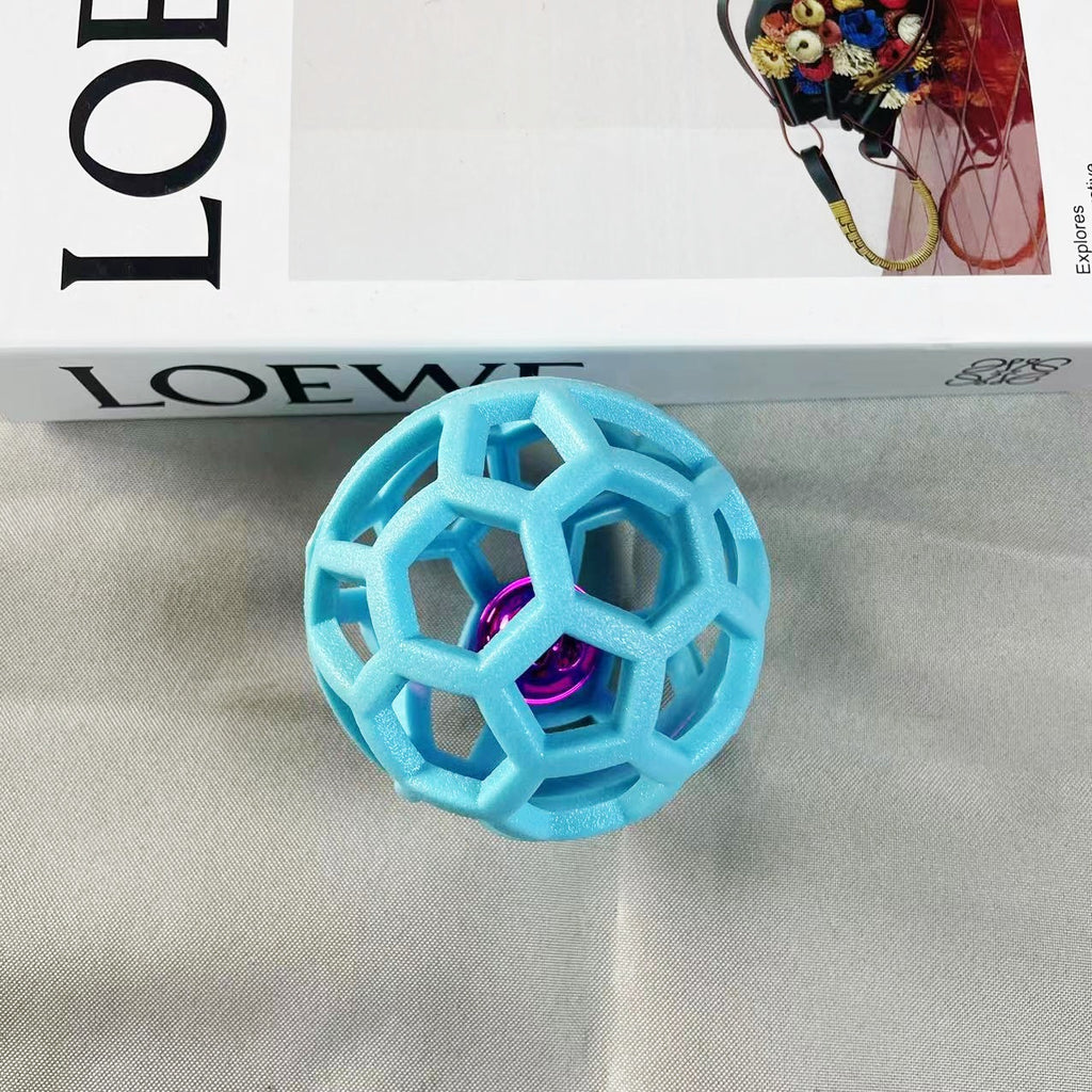 Light blue geometric dog chew ball with a metallic pink inner bell 