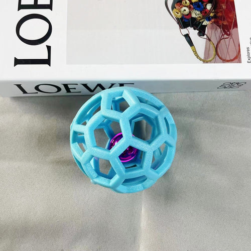 Light blue geometric dog chew ball with a metallic pink inner bell 