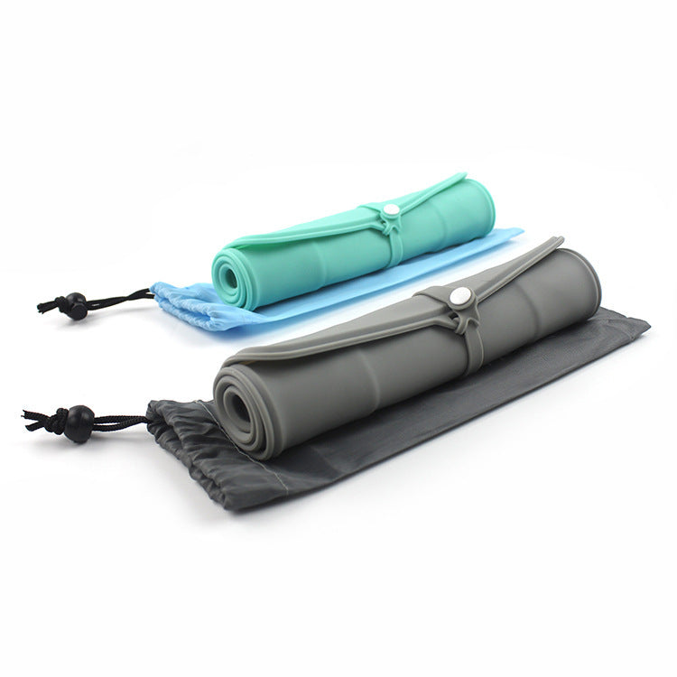 Two rolled silicone pet feeding mats in green and gray, each secured with a strap and placed on matching drawstring pouches