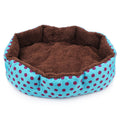 Pet bed with brown interior and blue exterior with pink polka dots on a white background