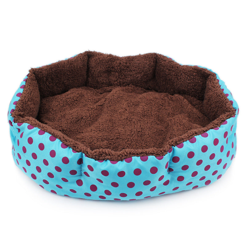Pet bed with brown interior and blue exterior with pink polka dots on a white background