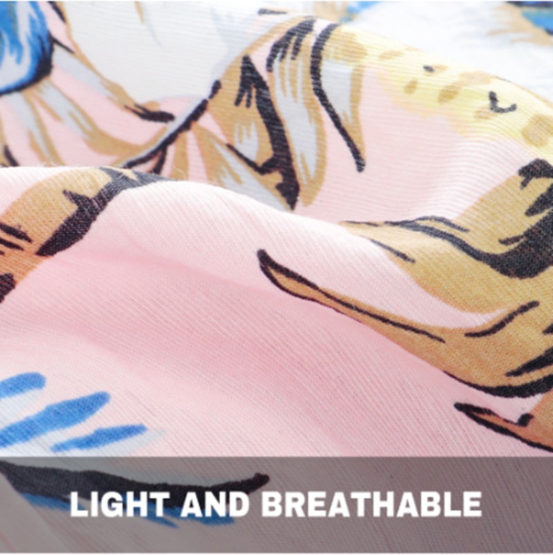 Close‑up of lightweight, breathable tropical fabric in pink with blue and beige printed details