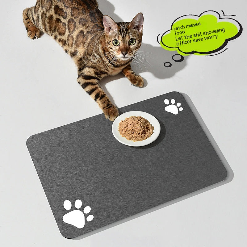 Cat lying on a large gray mat with a bowl of food, featuring paw prints and humorous text bubble.