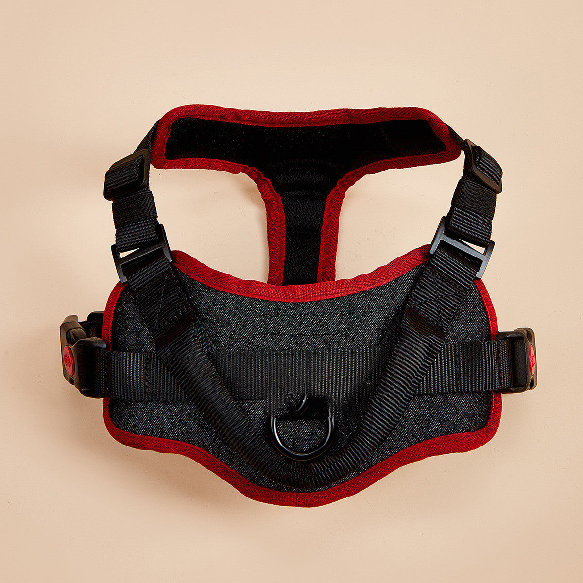 Black and red dog harness on a beige background