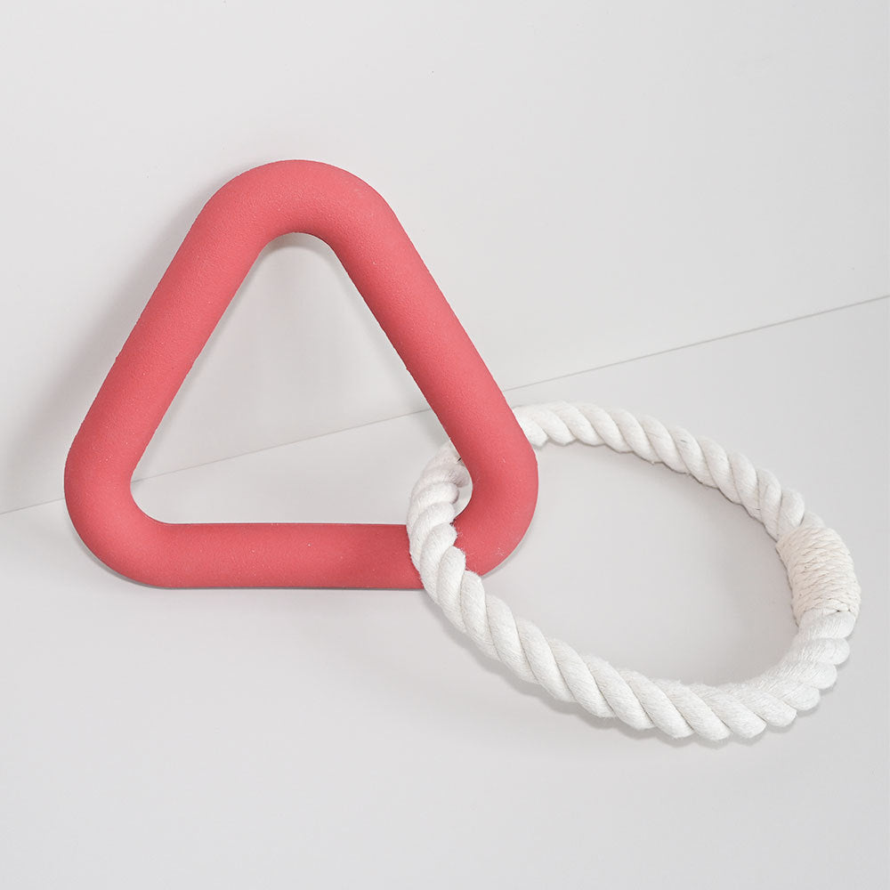 Red triangle-shaped toy with a white rope on a light gray background