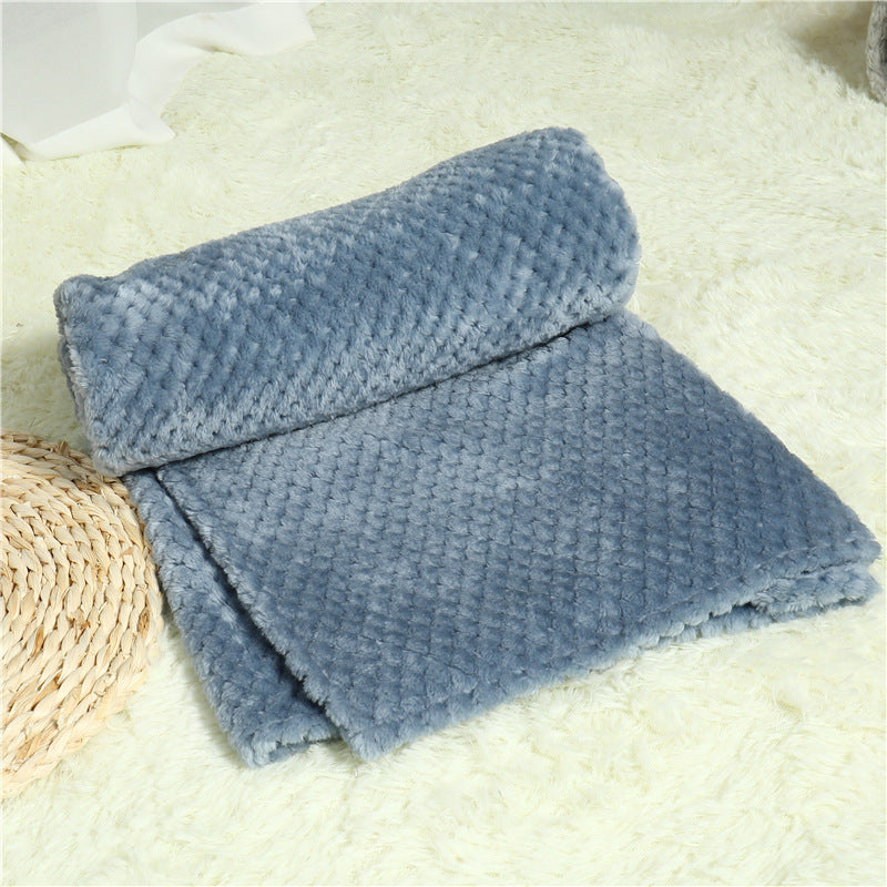 Folded blue blanket on a textured surface
