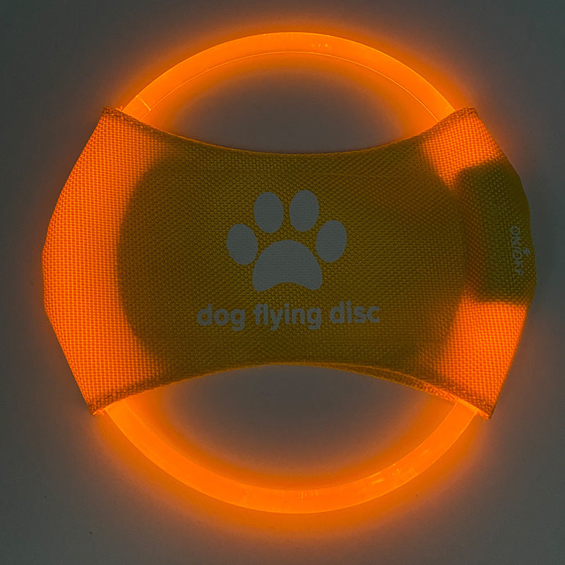 Yellow dog flying disc with a paw print and text on a dark background