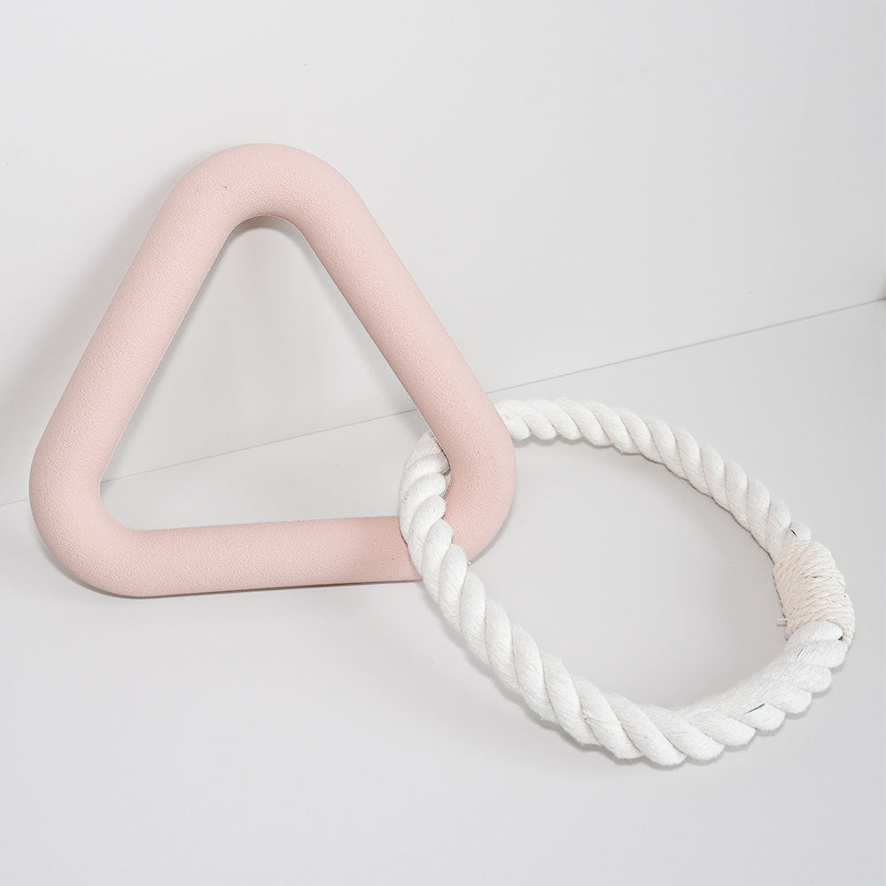 Pink triangle and white rope toy on a light gray background