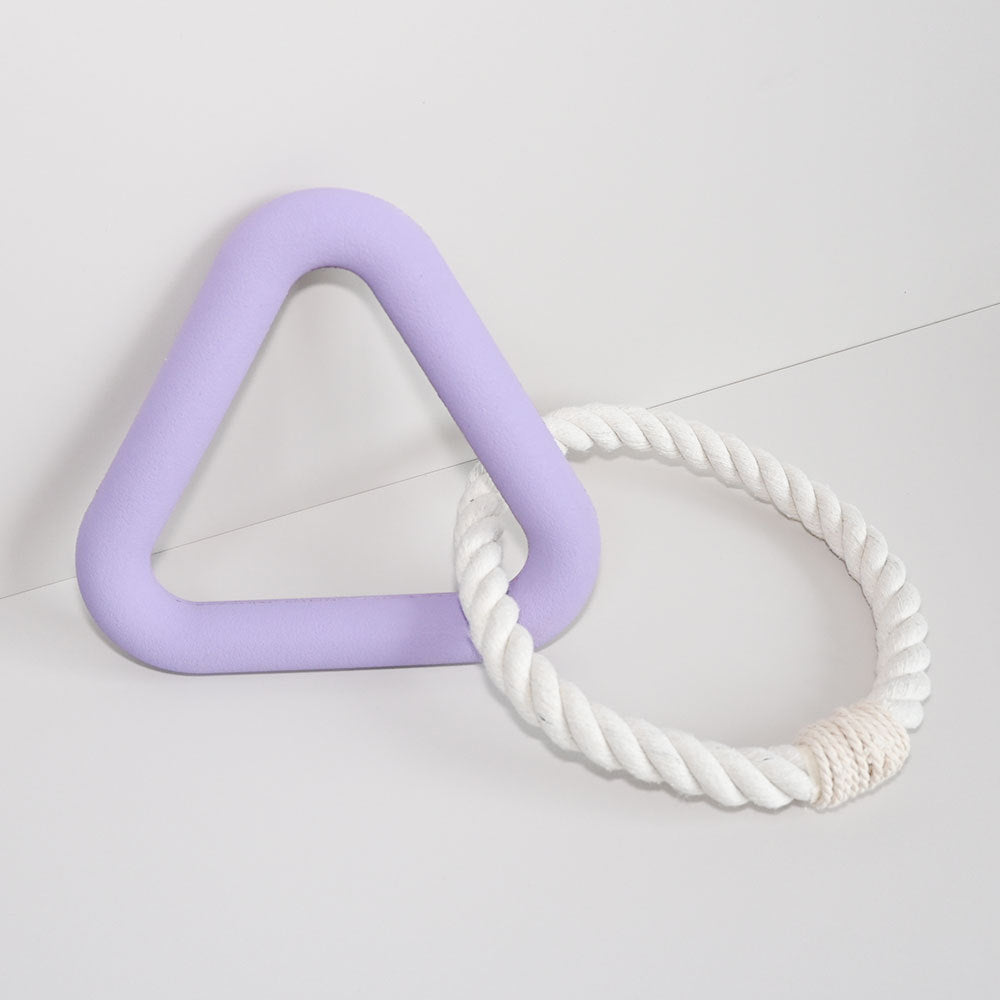 Purple triangle and white rope toy on a light gray background