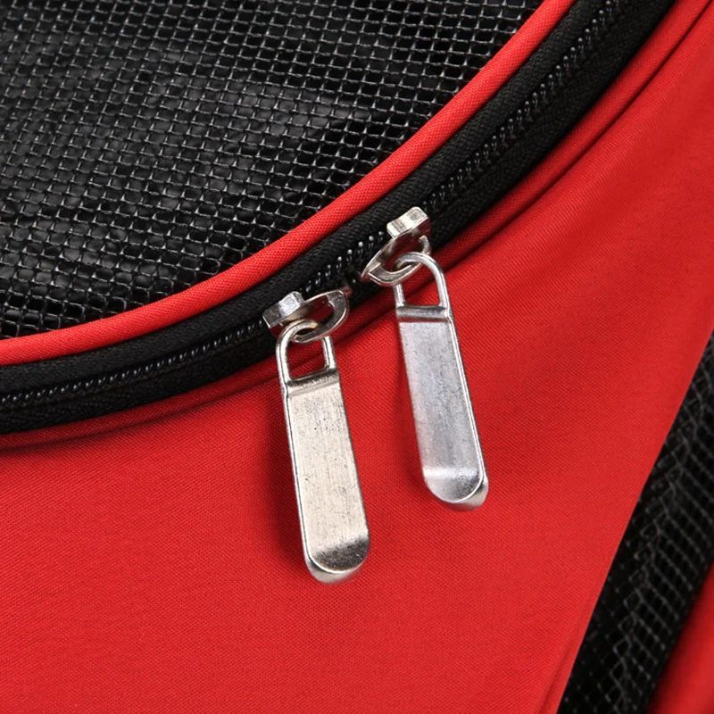 Close-up of a red bag with black mesh side and silver zipper pulls.